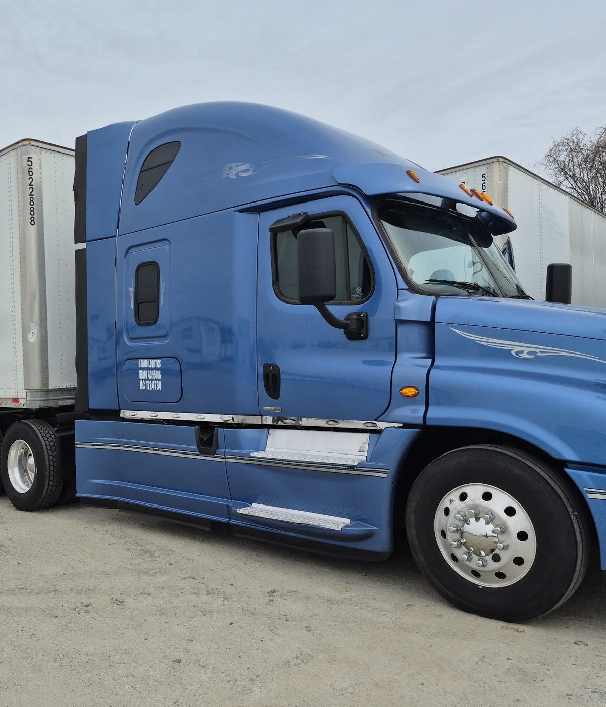 A Loaded Logistics tractor hooked to a dry van in a drop yard.