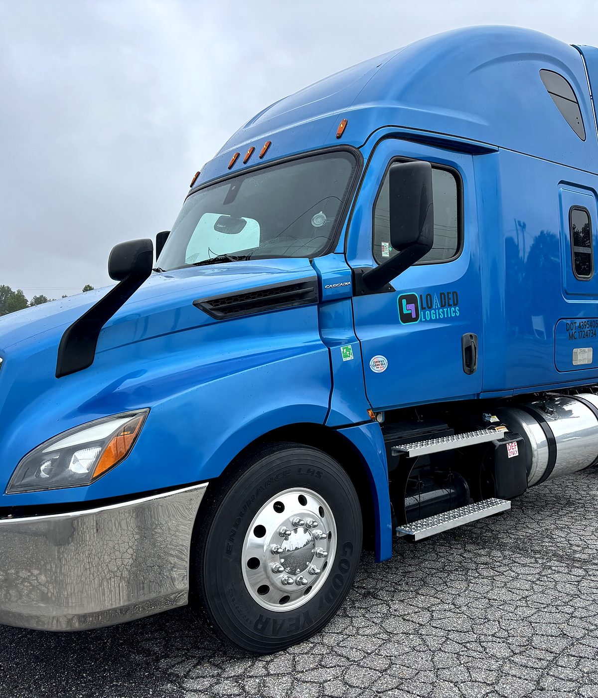 The Loaded Logistics Freightliner Cascadia with the company logo, USDOT and MC numbers on the cab door.